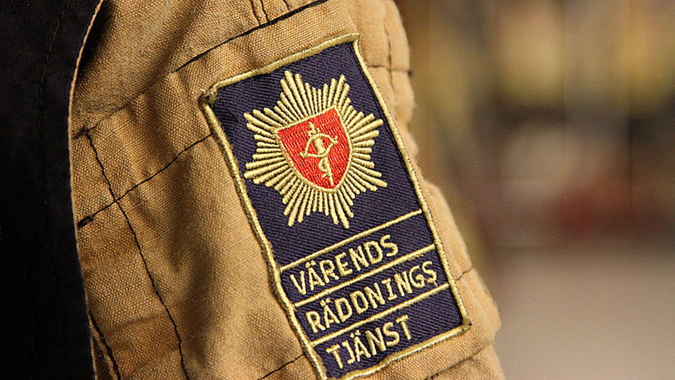 Närbild på en person som bär larmställ. På axeln ser man Värends Räddningstjänst logotyp.